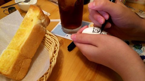 朝食そっちのけでゆで卵に絵を描き始める高3むすめ、いつも言うけどペンの持ち方が独特なんじゃあ！！